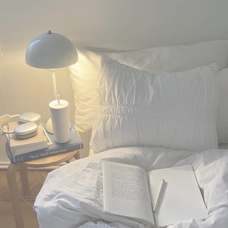 Quarto com livro aberto e luminária de cabeceira